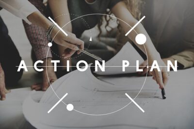 Personen mit einem Plan am Schreibtisch und dem Text "Action Plan" darüber.